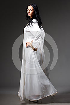 Fashion portrait of beautiful woman in elegant white dress