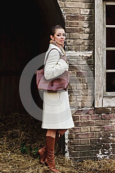 Fashion portrait of beautiful woman on the front of old vintage building