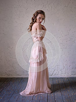 Fashion portrait of beautiful woman in a long pink dress.