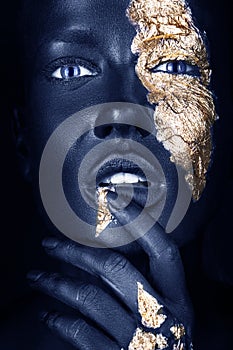 fashion portrait of a blue-skinned girl with gold make-up. Beauty face.