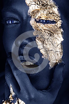 fashion portrait of a blue-skinned girl with gold make-up. Beauty face.