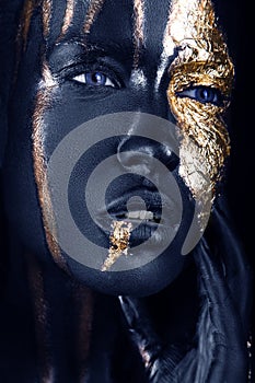 fashion portrait of a blue-skinned girl with gold make-up. Beauty face.