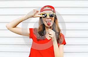 Fashion portrait cool girl with lollipop having fun over white