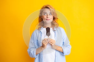 Fashion portrait cool young woman with ice cream over yellow background. Young cheeky hipster girl eating an ice cream