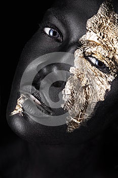 Fashion portrait of a dark-skinned girl with gold