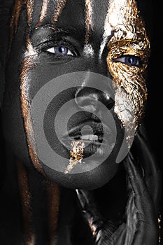 Fashion portrait of a dark-skinned girl with gold make-up. Beauty face.