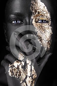 Fashion portrait of a dark-skinned girl with gold photo