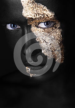 Fashion portrait of a dark-skinned girl with gold make-up. Beauty face. photo