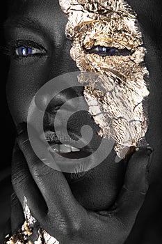 Fashion portrait of a dark-skinned girl with gold make-up. Beauty face. photo