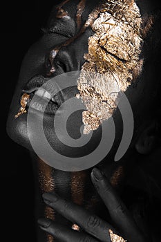 Fashion portrait of a dark-skinned girl with gold make-up. Beauty face.