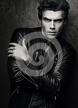 Fashion portrait of handsome young man in a black leather jacket