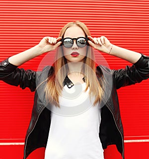 Fashion portrait pretty stylish woman with red lipstick wearing a rock black jacket and sunglasses