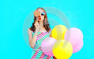 Fashion portrait pretty young woman with an air balloons, lollipop candy