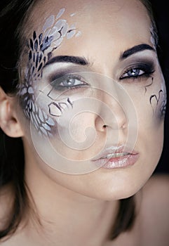 Fashion portrait of pretty young woman with creative make up like a snake