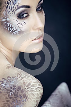 Fashion portrait of pretty young woman with creative make up like a snake