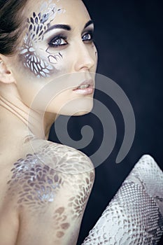 Fashion portrait of pretty young woman with creative make up like a snake