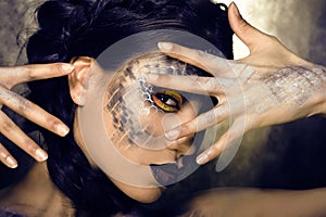 Fashion portrait of pretty young woman with creative make up like a snake