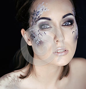 Fashion portrait of pretty young woman with creative make up like a snake, fashion victim with python skin clutch luxury