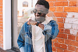 Fashion portrait smiling african man with smart watch using voice command