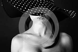 Fashion portrait of a woman with black and white dots hat and pout lips