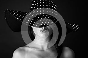 Fashion portrait of a woman with black and white dots hat and pout lips
