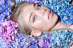 Fashion portrait of woman. Healthy hair and skin. Summer beauty. Spring woman with hydrangea flowers. Makeup cosmetics