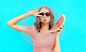 Fashion portrait woman is holding slice of watermelon and blowing lips
