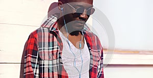 Fashion portrait young african man listens to music in headphones