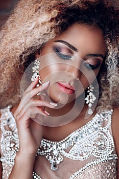 Fashion portrait of young beautiful afro american woman with jewelry and evening make-up.