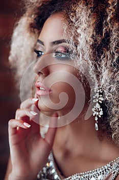 Fashion portrait of young beautiful afro american woman with jewelry and evening make-up.