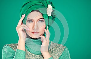 Fashion portrait of young beautiful muslim woman with green cost