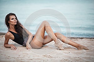 fashion portrait of young beautiful woman in black swinsuit