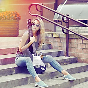 Fashion portrait of young beautiful woman with guitar