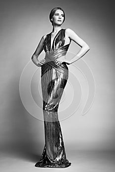 Fashion portrait of young beautiful woman in silver dress