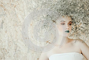 Fashion portrait of Young blond woman in white dress .Beautiful woman with green lips. Concept of Mother Nature