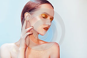 Fashion portrait of young elegant girl. Paslet background, studio shot. Beautiful brunette woman with gold lips and golden bright