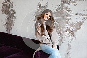 Fashion portrait of young hipster woman in a grey hoodie indoors