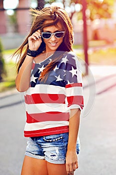 Fashion portrait of young hipster woman wearing sunglasses at sunset, american style