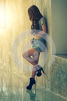Fashion portrait of young model posing by the wall