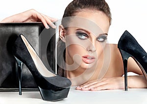 Fashion portrait of young pretty woman with fashionable high heel shoe and packing box