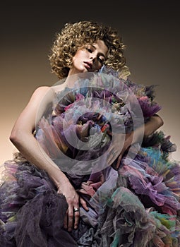 Fashion portrait of young woman with curly hair and a puffy dress