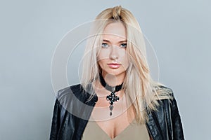 Fashion portrait of young woman with make-up and long blonde hair against white studio wall background