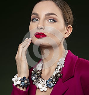 Fashion portrait of young woman in red with jewellery necklace