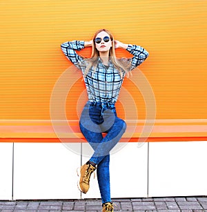 Fashion pretty blonde girl posing over orange background
