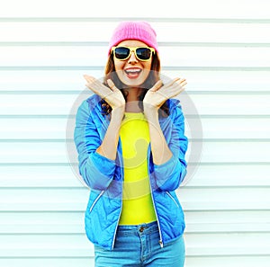 Fashion pretty cool shocked woman in colorful clothes having fun over white background wearing a pink hat yellow sunglasses