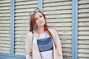 Fashion pretty redhead woman wearing in a pink jacket and stylish jeans