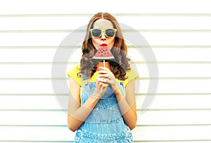 Fashion pretty woman eating a slice of watermelon in the form of ice cream on white background