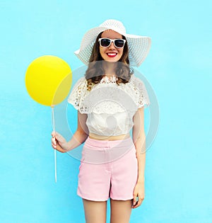 Fashion pretty woman in straw hat with air balloon over colorful blue