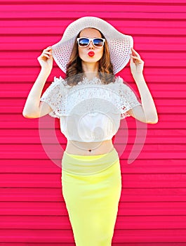 Fashion pretty woman in summer straw hat and skirt over colorful pink