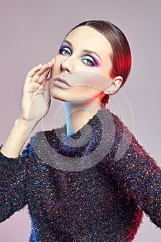 Fashion redhead art portrait of a woman in shiny blouse with a bright contrasting makeup. Creative beauty photo of a girl